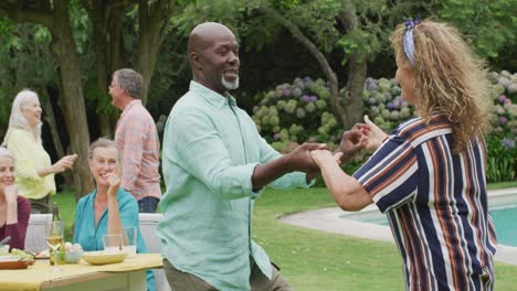 Felices-Y-Diversos-Amigos-Masculinos-Y-Femeninos-Bailando-En-El-Jardín-Mientras-Almuerzan-Con-Amigos