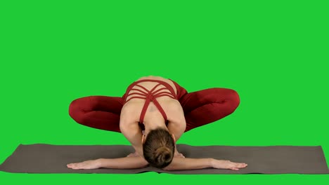 fitness woman training yoga doing exotic pose on a green screen, chroma key