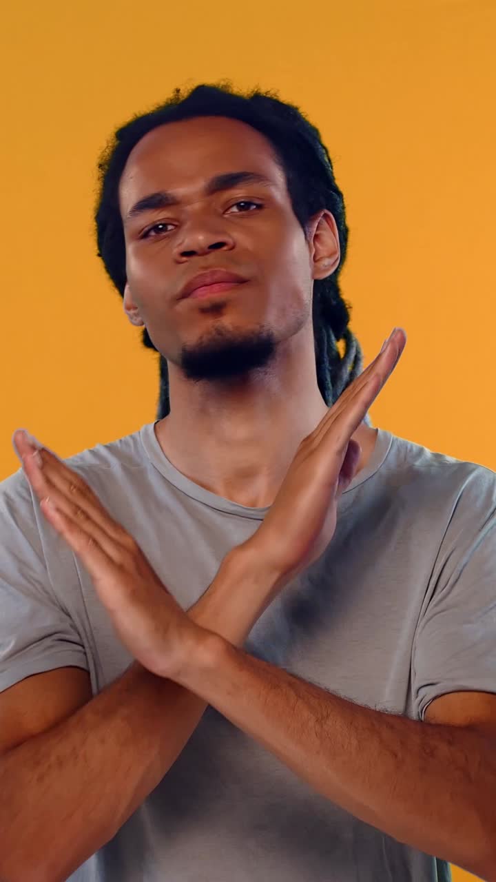 Young Man with Dreadlocks Making a Stop Gesture
