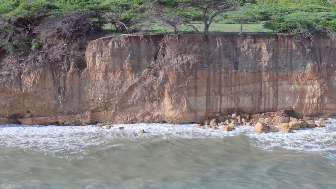 vuelo lateral que muestra las olas chocando contra los acantilados en la playa de matanzas en la isla de la república dominicana