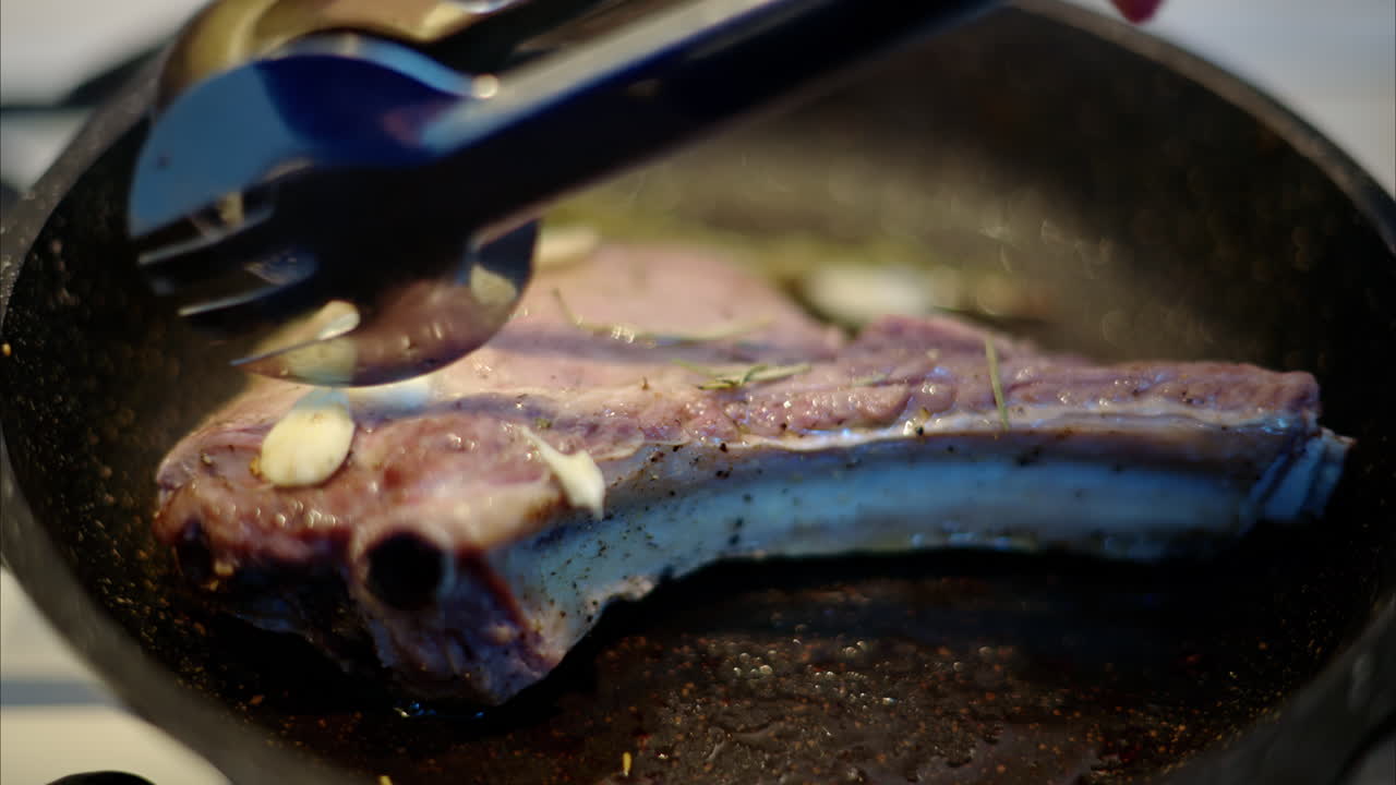 Juicy ribeye steak meat beef being prepared with rosemary and garlic