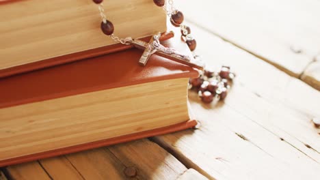 close up of books and rosary on white background with copy space