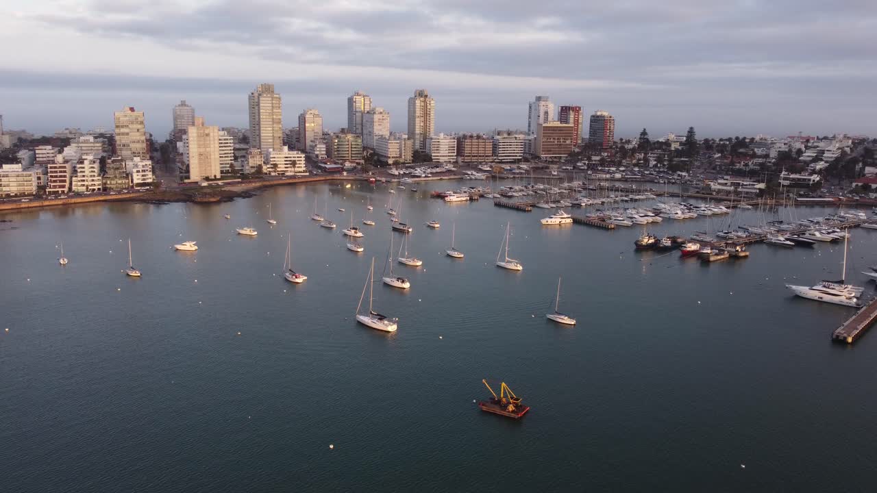 Barche a vela ormeggiate nel porto di Punta del Este con grattacieli sullo sfondo al tramonto, Uruguay