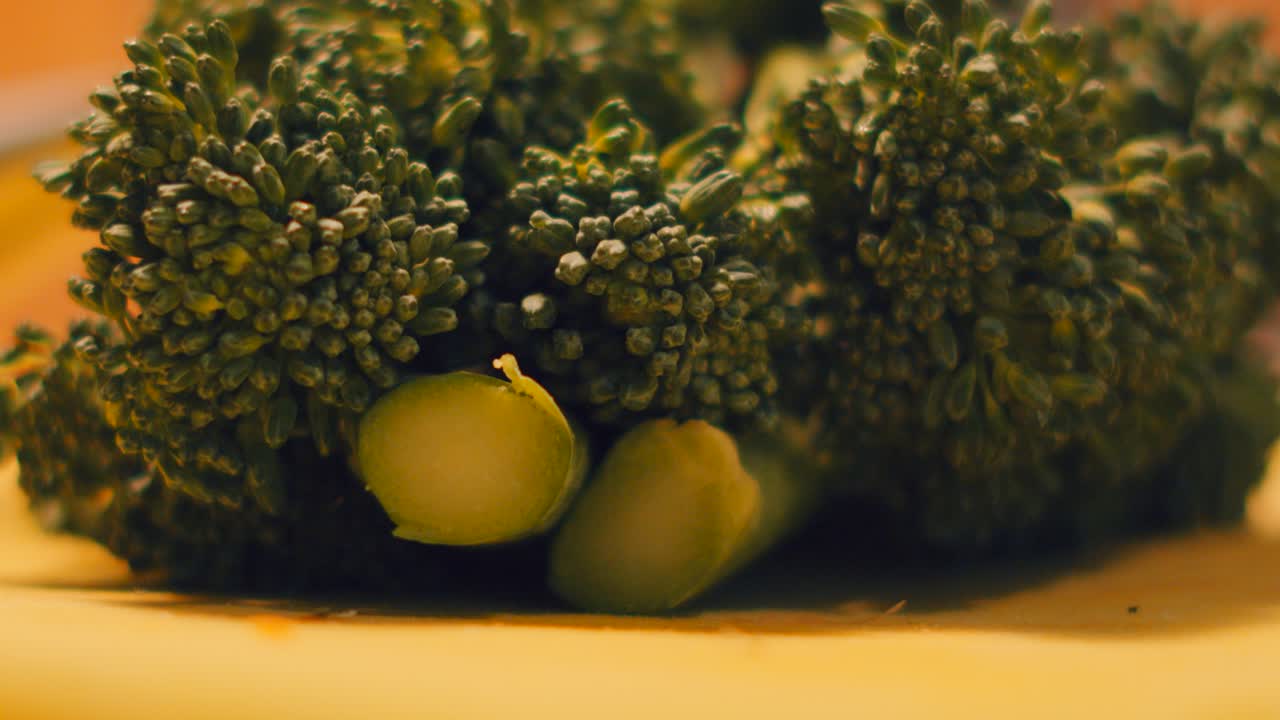 Very Slow Pan Up Reveal Close Up of Tenderstem Broccoli Resting on Chopping Board After Preparing. Healthy Organic Food Ready to Steam or Boil. Elegant High Quality Home Cooking Clip