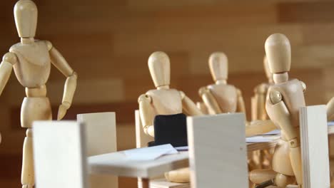 figuras de madera que se reúnen en la sala de conferencias