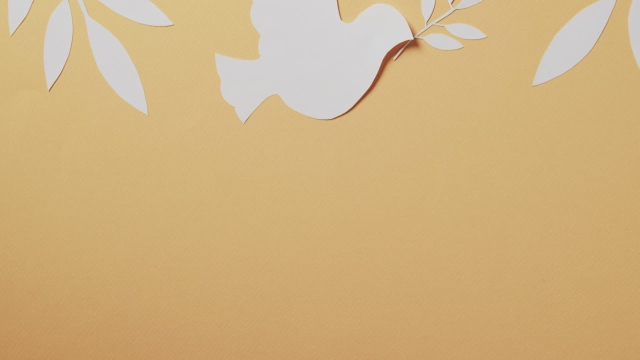 노란색 배경에 잎과 복사 공간을 가진  ⁇  비둘기의 클로즈업