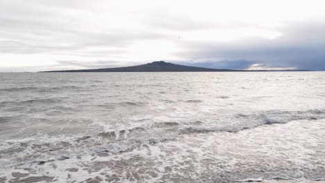 在一個雲<unk>的春天的早晨,從岸邊到rangitoto島的靜態廣角景色