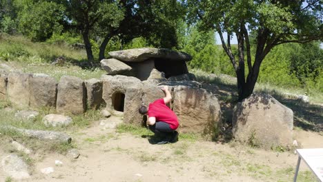 Tourist-Visiting-The-Natural-Landmark-Of-Dolmen-Nachevi-Chairi-Near-Village-Hlyabovo-In-Bulgaria