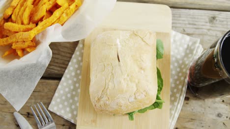 Hamburger,-french-fries-and-cold-drink-on-wooden-table