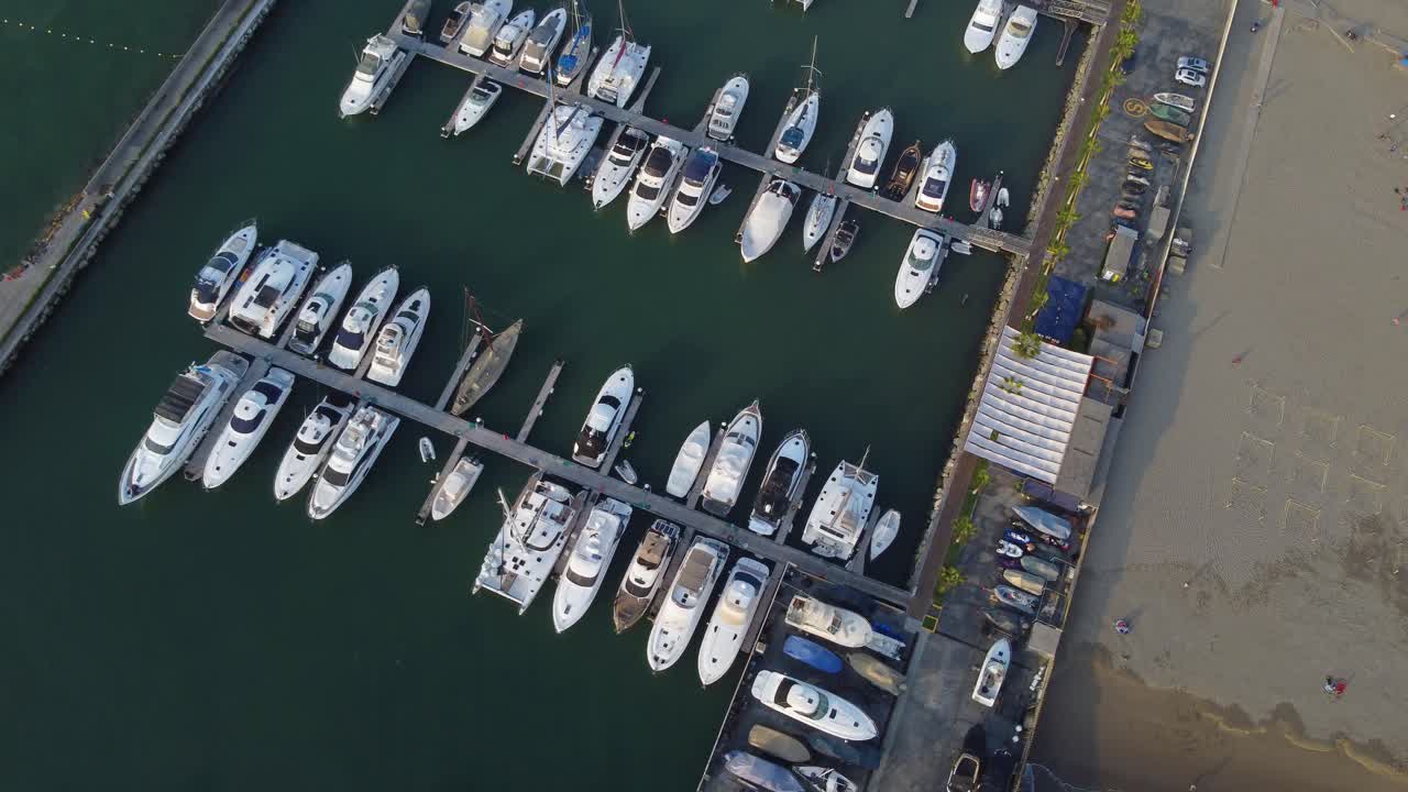 Dronevideo av en marina med mange båter fortøyd eller parkert.