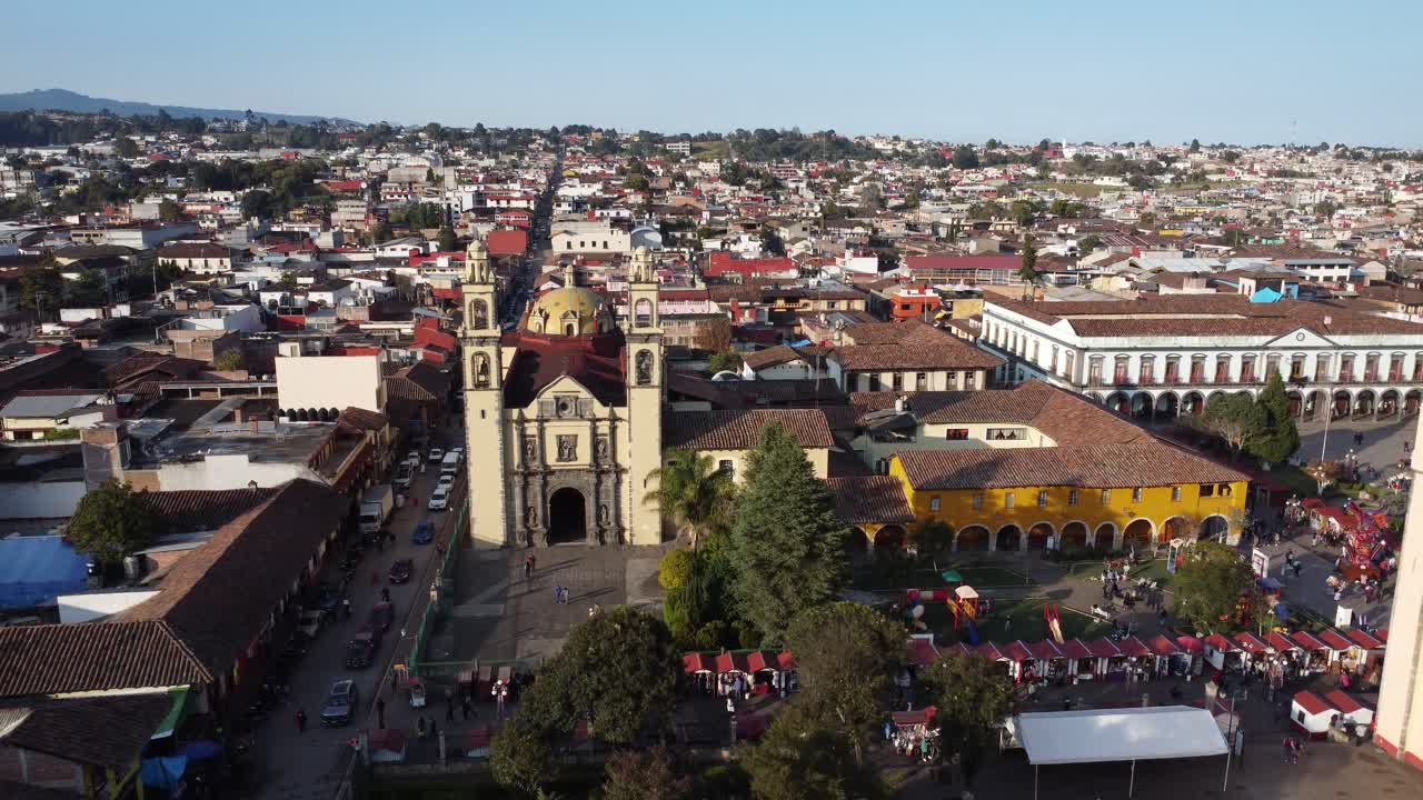 el centro histórico de zacatlán lleno de casas tradicionales con techos de azulejos rojos y la fachada de la iglesia católica parroquial de san pedro en el medio, puebla, méxico, vista aérea