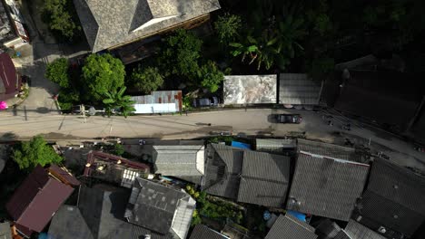 looking down at road flanked by old wooden houses in thai mountain village