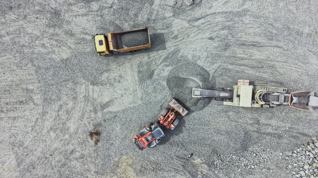 Granite quarry activity showing trucks and machinery during the extraction process at a site in the afternoon