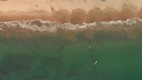 antena: barco en la playa y olas desde arriba
