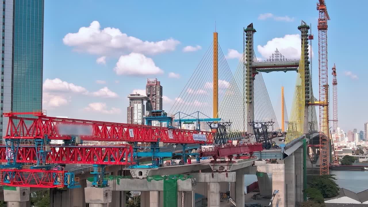 Construction of a bridge in Bangkok with cranes and workers present