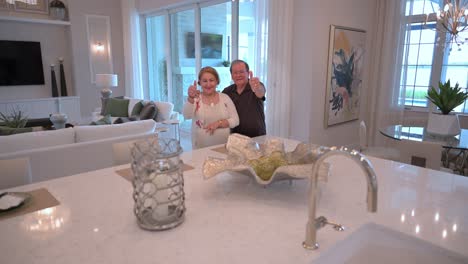 husband and wife raise their thumbs to show the approve of the completion of their new kitchen project