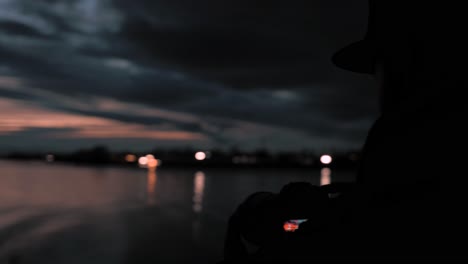 Hombre-Usando-Una-Cámara-Digital-Dslr-Montada-En-Un-Trípode-De-Cardán-Para-Fotografiar-Nubes-Tormentosas-Oscuras-En-Una-Noche-De-Iluminación-Dramática-Oscura