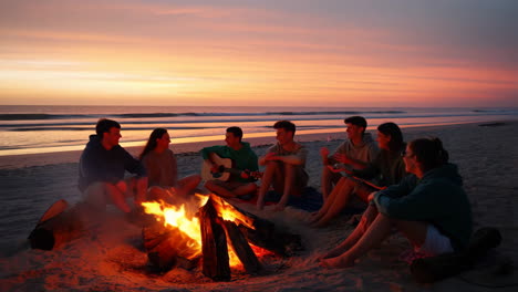 friends enjoying a beach bonfire at sunset