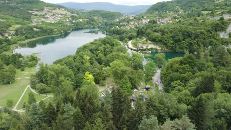 Vista-Panorámica-Aérea-De-Un-Grupo-De-Pequeños-Molinos-De-Agua-De-Madera-En-El-Bosque,-Jajce