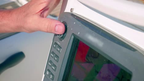 captain pushing navigation button in a boat - close up