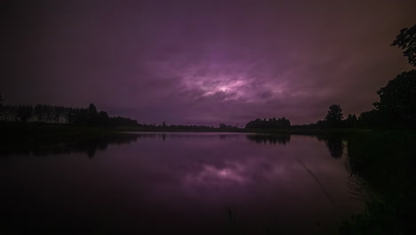 Lapso-De-Tiempo-De-Un-Lago-Con-Un-Cielo-Estrellado-Al-Atardecer-Que-Se-Convierte-En-Uno-Tormentoso-Cuando-Los-Vehículos-Pasan-Por-Un-Puente