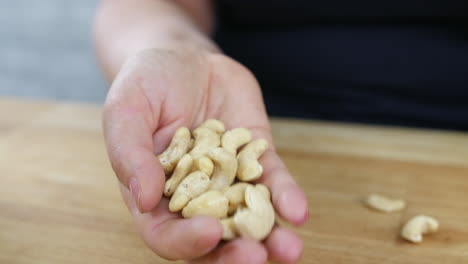 an unrecognizable female holding cashews