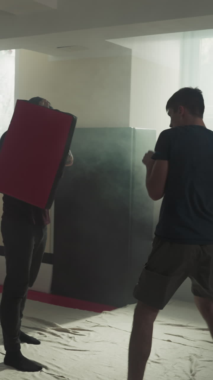 los deportistas entrenan golpes con bolsas de boxeo en el club deportivo. los kickboxers profesionales hacen ejercicios en equipo en el gimnasio de lucha en cámara lenta. ocio y actividad saludable