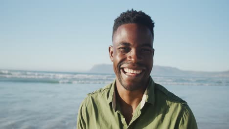 portrait of happy african american man on sunny beach