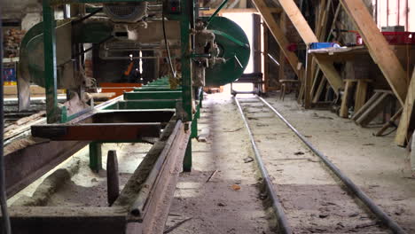 empty sawmill with bandsaw equipment and plank pile, handheld dolly in