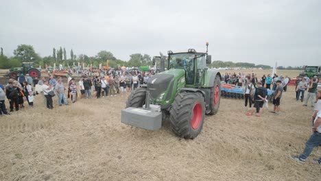 demostración de maquinaria agrícola en una exposición. los tractores operan en el campo, mostrando sus capacidades y rendimiento en acción