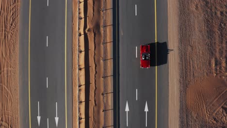 Man-Driving-Red-Classic-Convertible-Car-On-Desolate-Desert-Road---aerial-top-down,-tracking-shot