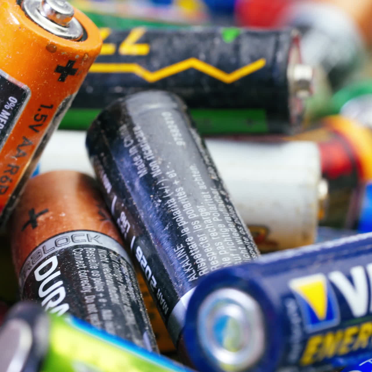 Multiple used Varta AA alkaline batteries are seen arranged in a pile. Hazardous waste concept
