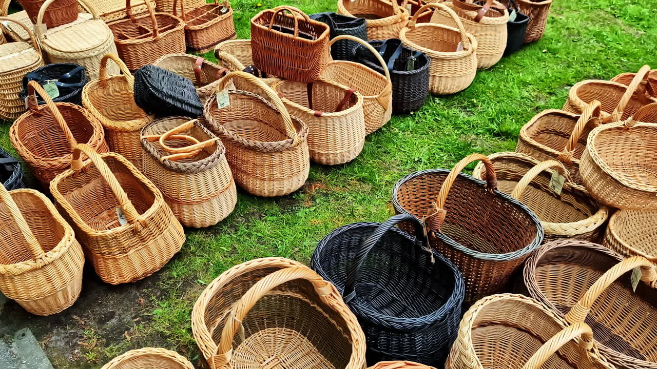 Wicker baskets displayed in a market, various shapes and sizes, some with tags