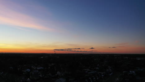 an aerial shot over a suburban neighborhood during a golden sunrise
