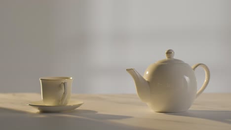 studio shot of person making traditional british cup of tea using teapot 1