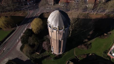 top down and dramatic aerial rotating pan of former dutch brick water tower in zutphen now repurposed as a residential home