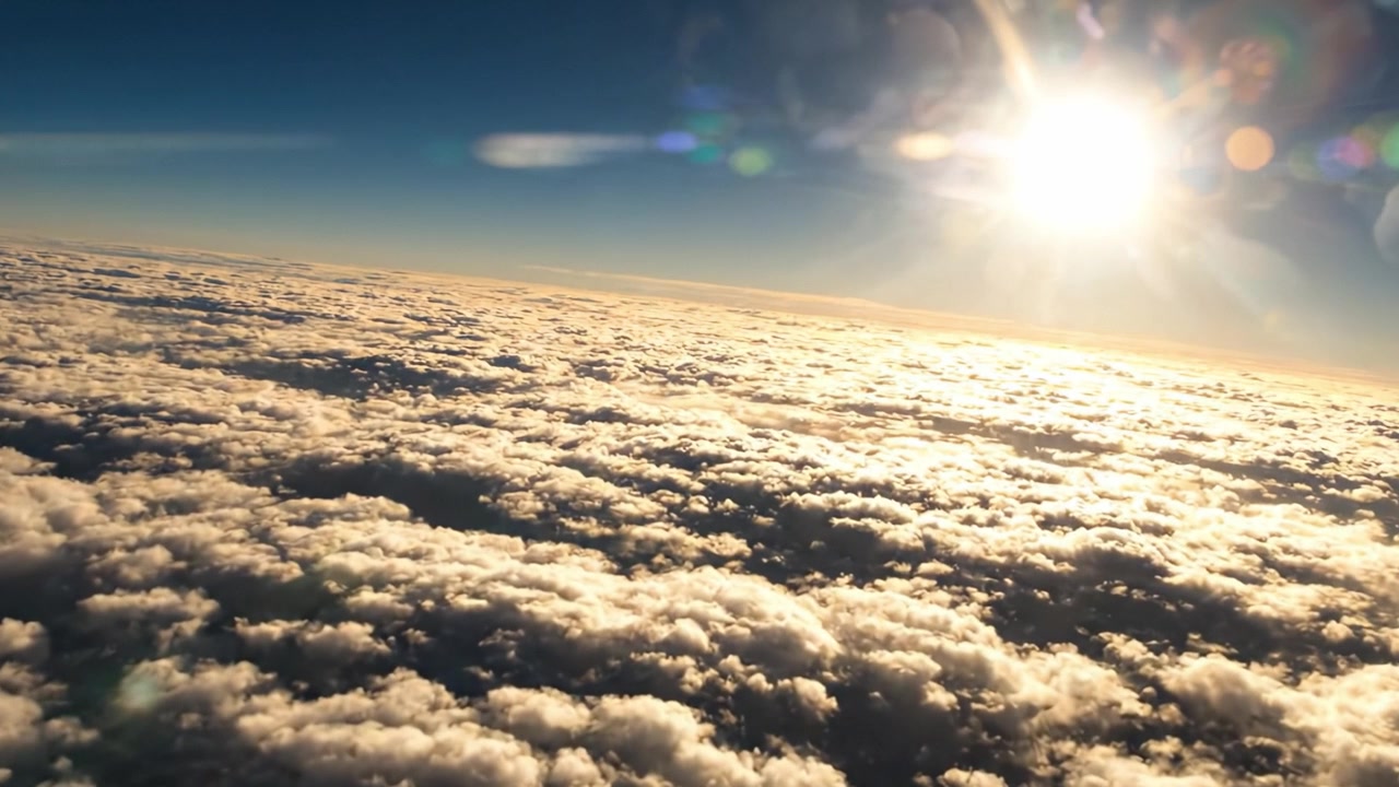 Una vista mozzafiato del sole che splende su un mare di nuvole, catturata dall'alto, evidenziando la bellezza della natura nel cielo