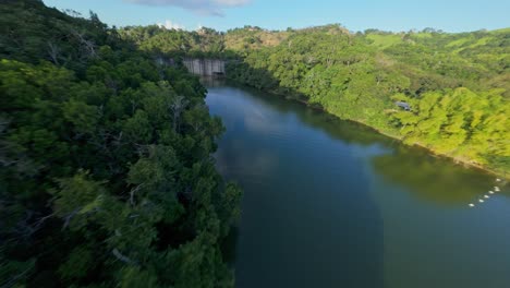 hatillo dam, concrete structure surrounded by lush greenery, cotui in dominican republic drone flying under bulkheads, aerial fpv