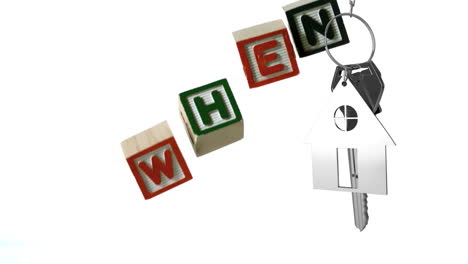 Animation of wooden blocks with text when and silver house shape with key on white background