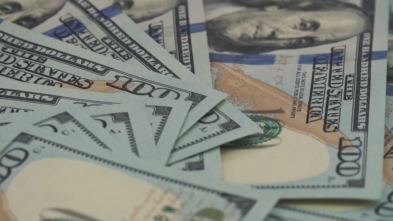 Close-up detalhado de notas de cem dólares americanos abertas em leque