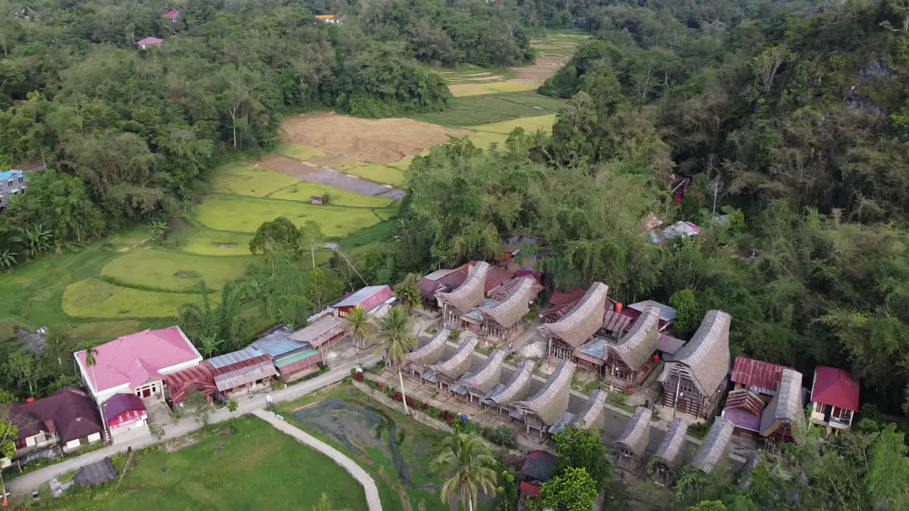 Aerial View of a Traditional Village Amidst Lush Green Mountains and Rice Fields