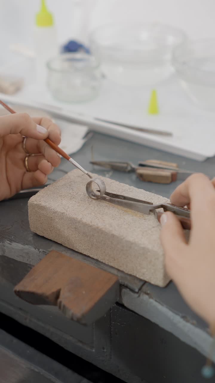 Hands working on jewelry in a workshop