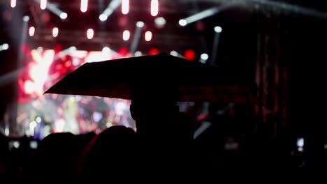 happy people watch an amazing music concert under umbrellas in the rain