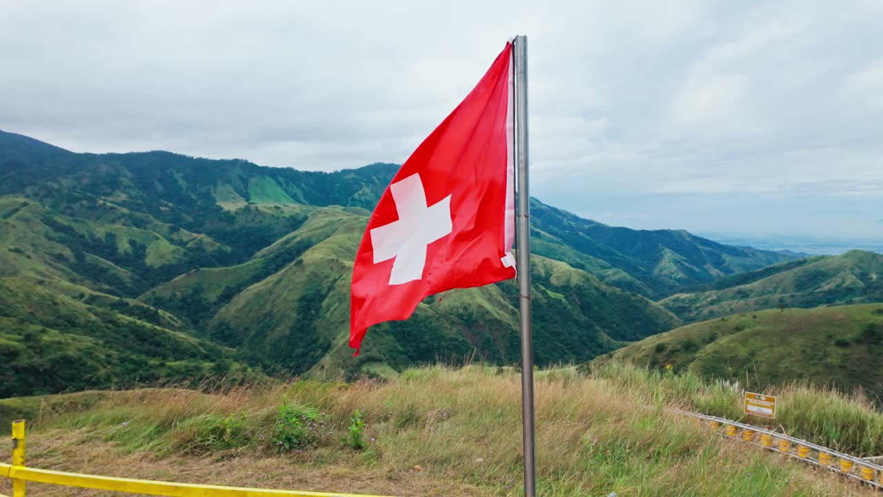 Zeitlupenkamera bewegt sich näher zur Schweizer Flagge auf dem Zürich-Hügel, Pangasinan, Philippinen
