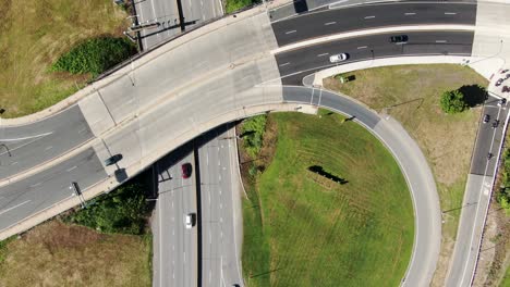 Top-down-overhead-aerial-of-traffic-on-roads,-overpass-bridge,-travel-transportation-fuel-prices,-holiday-travel,-commute,-commuter-theme,-vehicle-safety