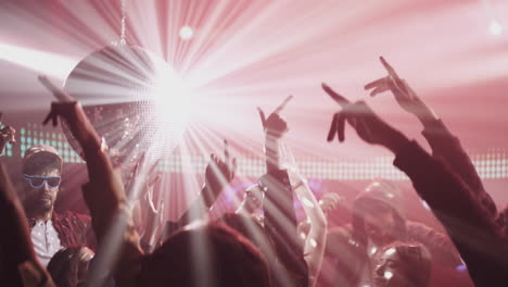 people dancing at a nightclub with a disco ball