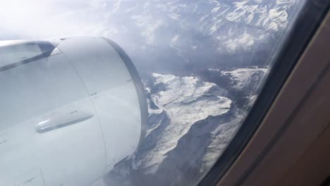 Blick-Auf-Die-Turbine-Aus-Einem-Flugzeug,-Das-In-Der-Nähe-Der-Verschneiten-Berge-Der-Alpen-In-Europa-Fliegt