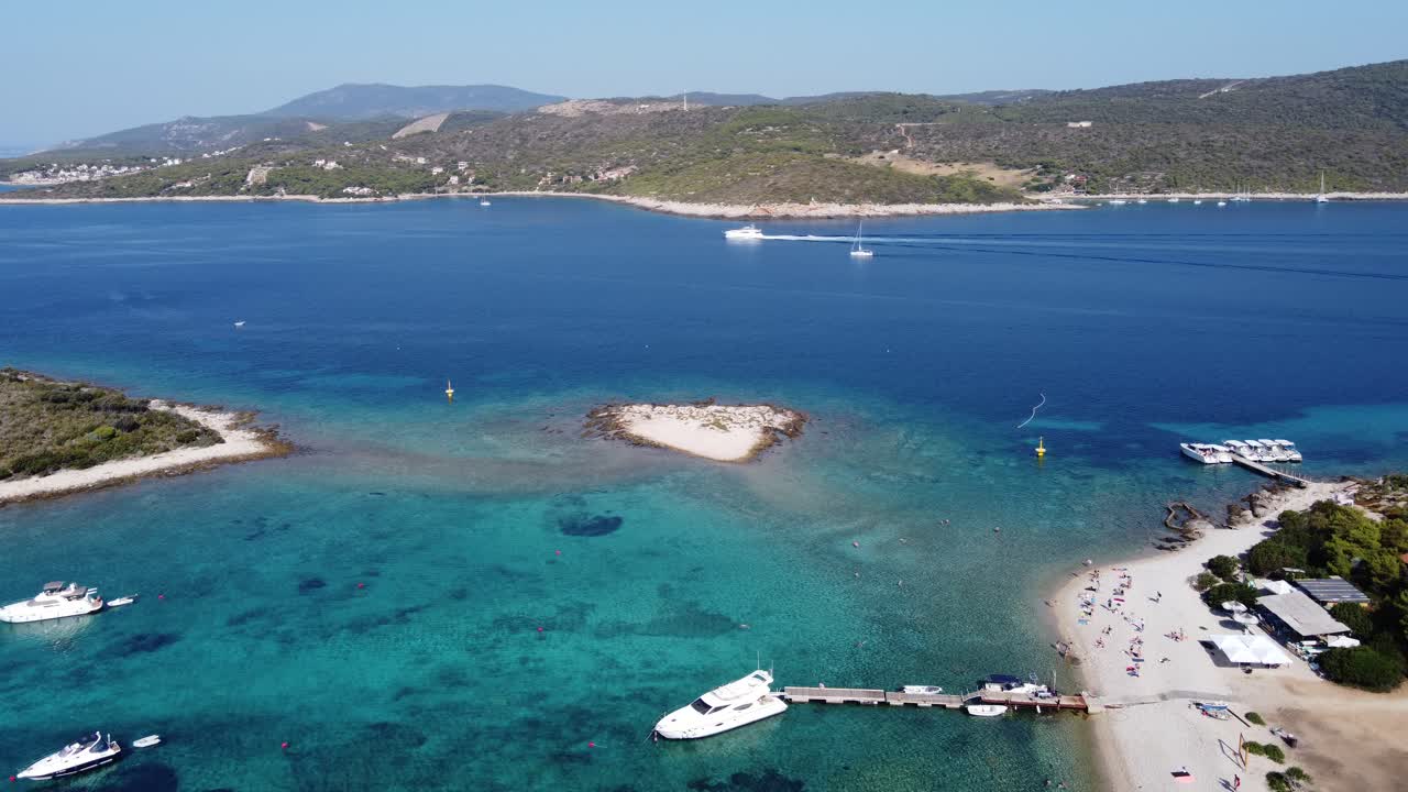 People relaxing at Blue Lagoon Beach of Veliki Budikovac island with their Yachts anchored at Archipelago bay