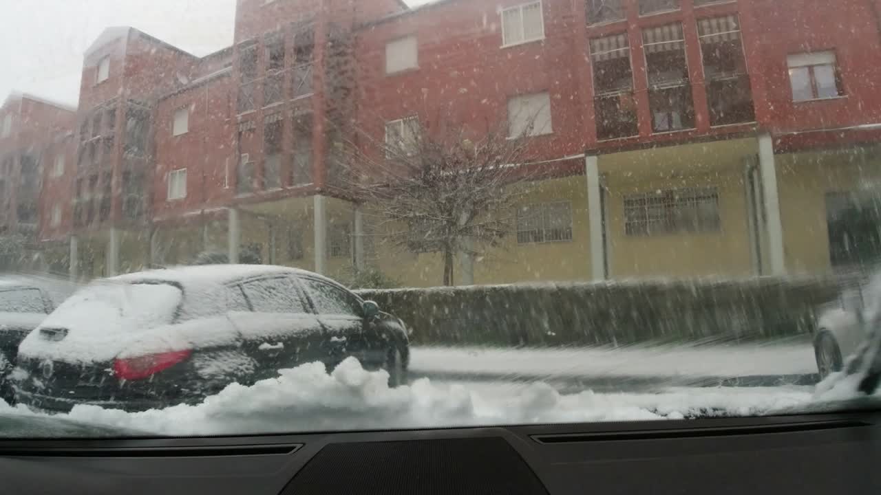 Starting the journey with the car in a heavy snow on an iced snowy road with low visibility. Italy, Bologna, December 2019.