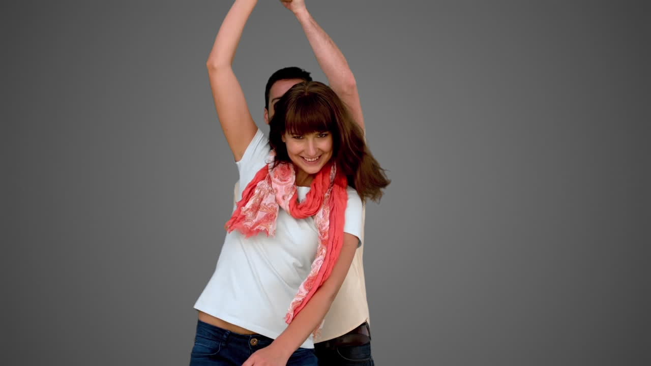 Cute couple dancing on grey background